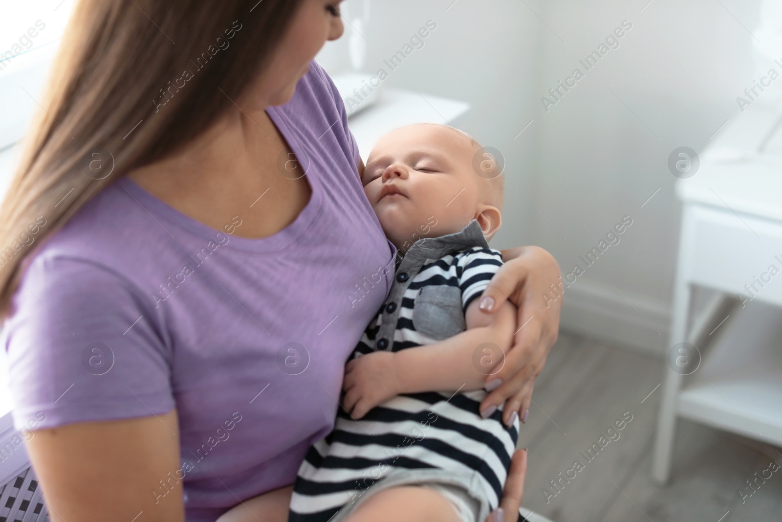 Photo of Mother with her sleeping baby at home, closeup view