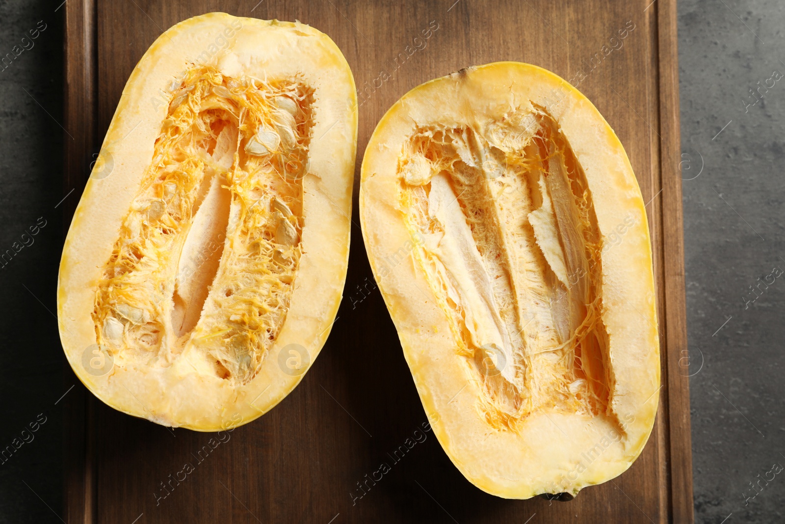 Photo of Cut spaghetti squash on wooden board, top view