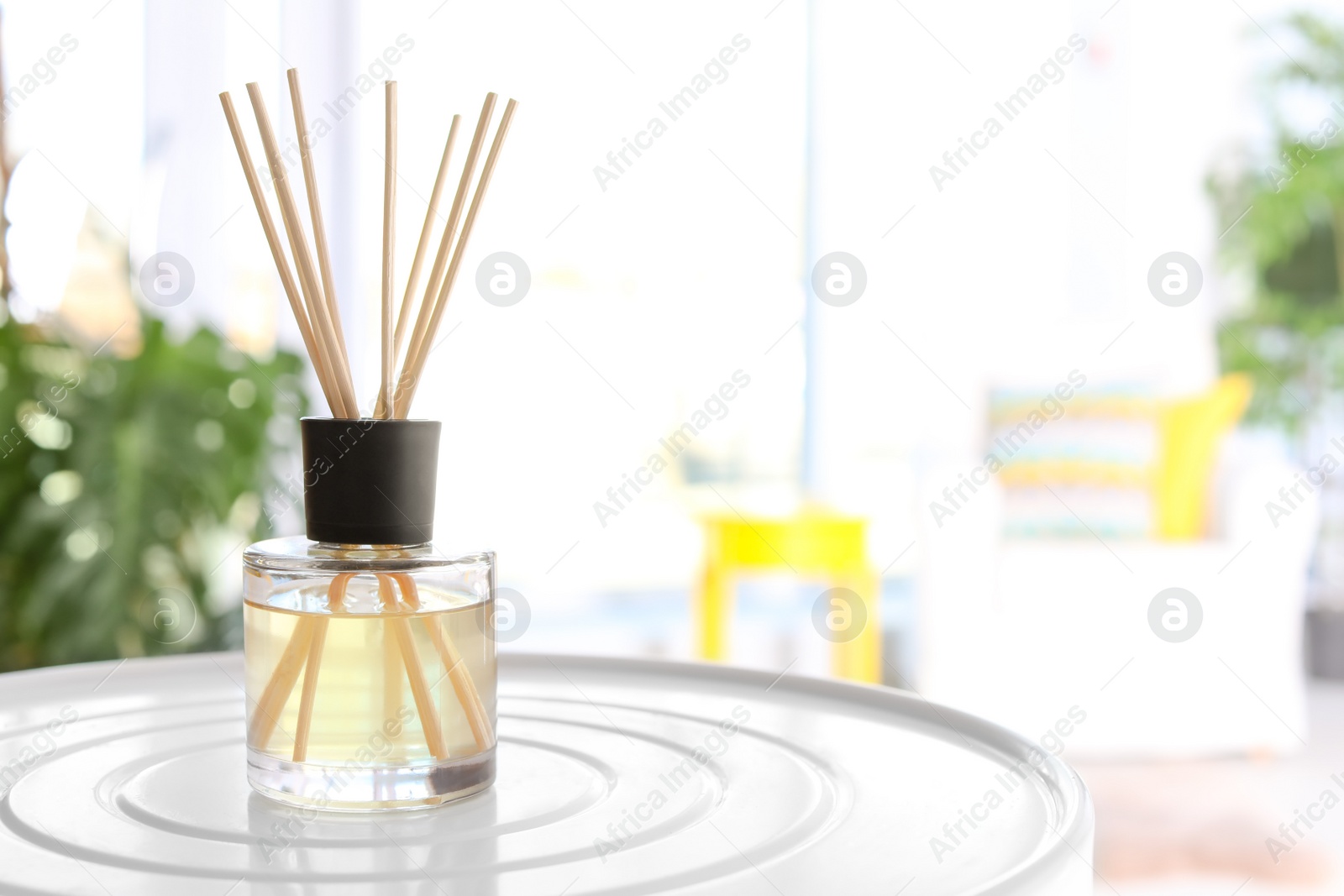 Photo of Reed freshener on table in light room, closeup