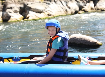 Photo of Little boy kayaking on river. Summer camp