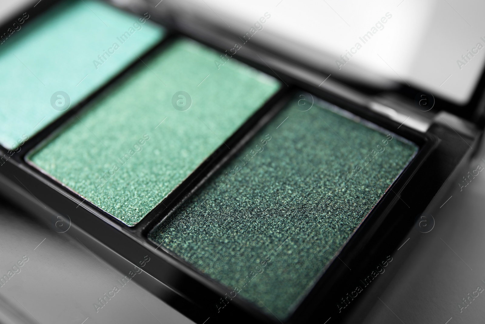 Photo of Beautiful eyeshadow palette on light gray background, closeup. Professional cosmetic product