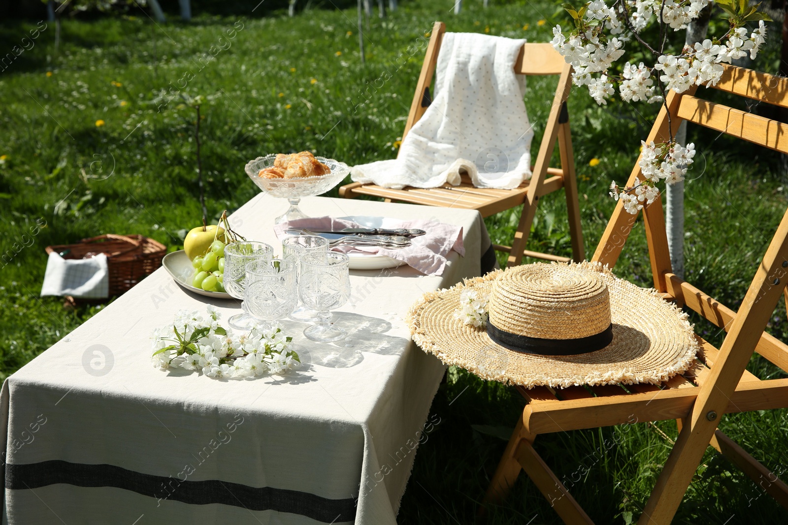 Photo of Stylish table setting with beautiful spring flowers in garden on sunny day