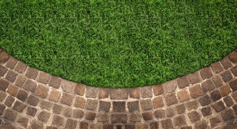 Fresh green grass and stone tiles outdoors, top view. Banner design