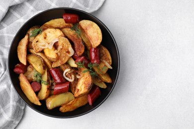 Photo of Delicious baked potato with thin dry smoked sausages, onion and dill in bowl on gray table, top view. Space for text