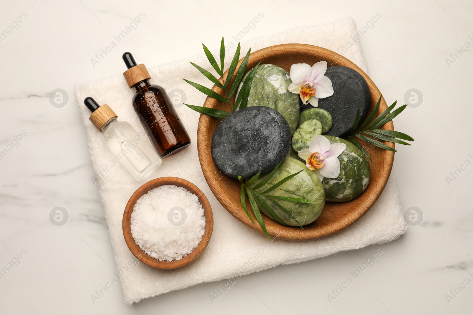 Photo of Flat lay composition with different spa products and flowers on white marble table