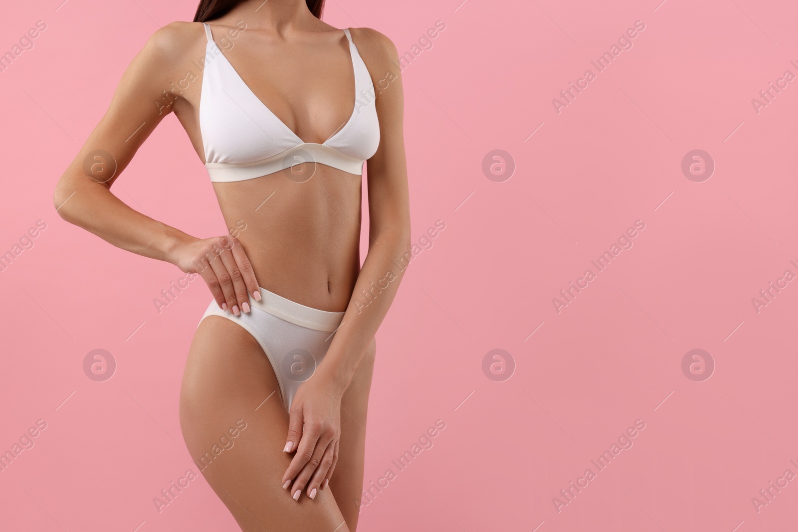 Photo of Young woman in stylish white bikini on pink background, closeup. Space for text