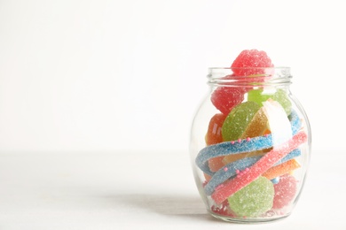 Photo of Delicious colorful candies on white table. Space for text