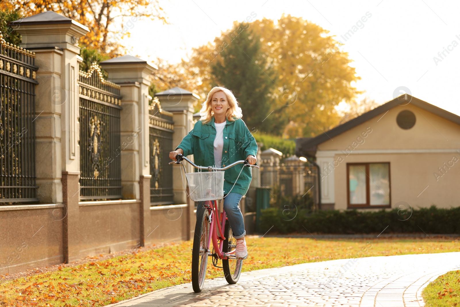 Photo of Mature woman riding bicycle outdoors. Active lifestyle