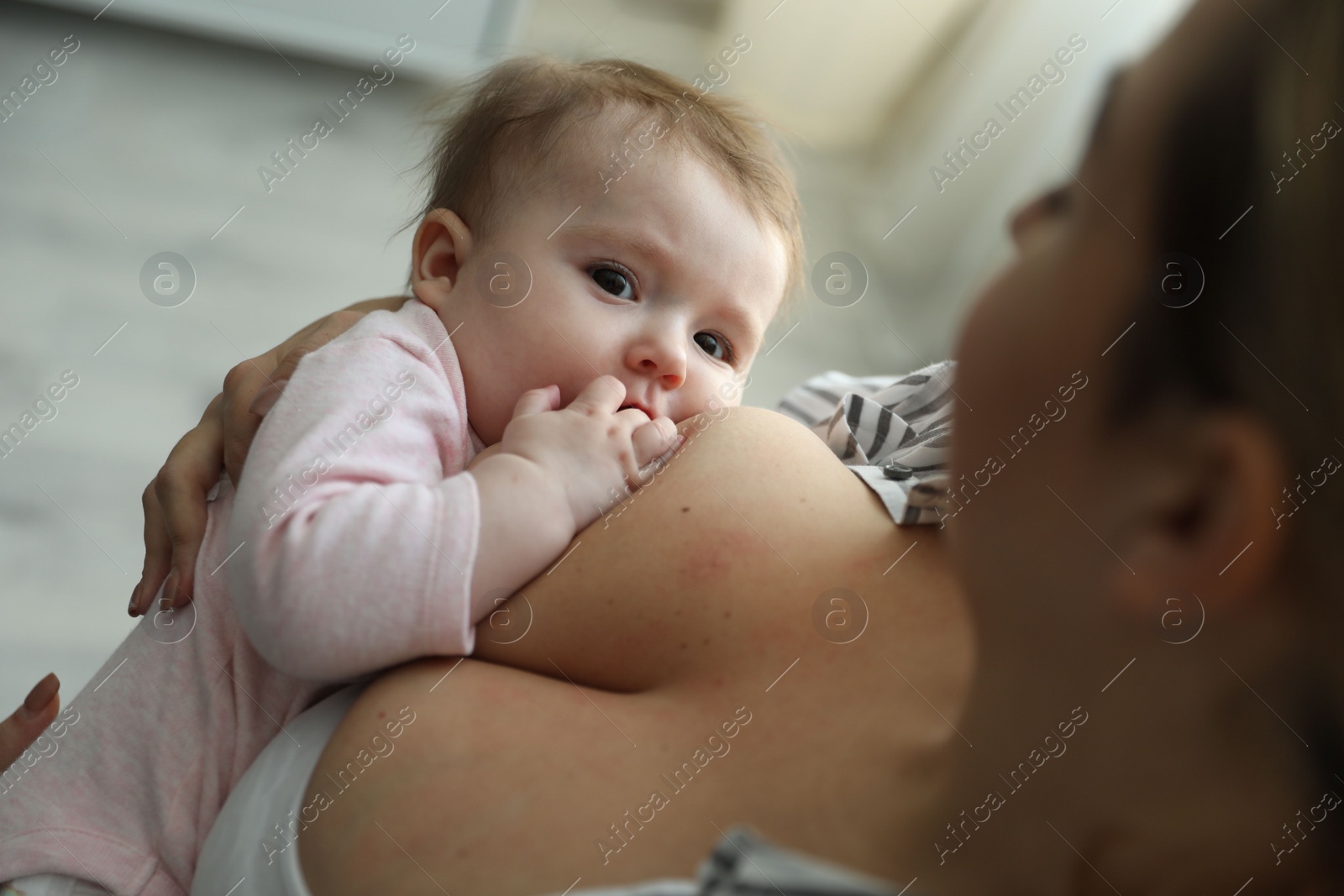 Photo of Young woman breastfeeding her baby at home, closeup