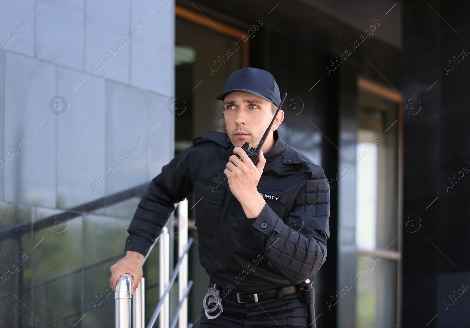 Photo of Male security guard using portable radio transmitter outdoors