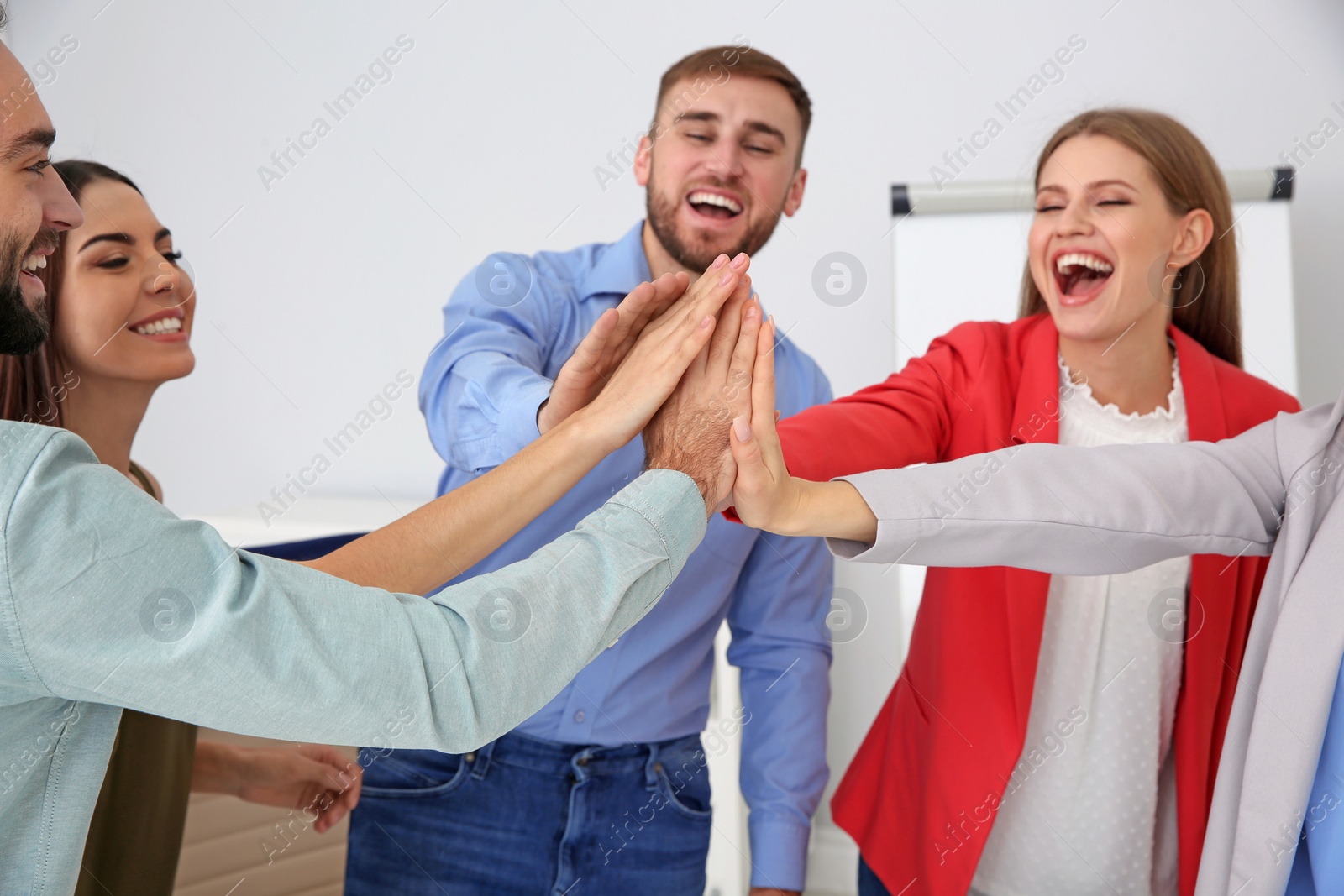 Photo of Group of office employees celebrating victory at workplace