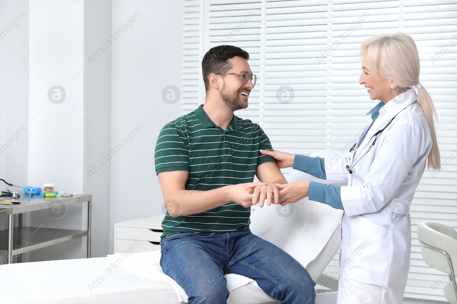 Photo of Doctor checking patient's pulse during consultation in clinic