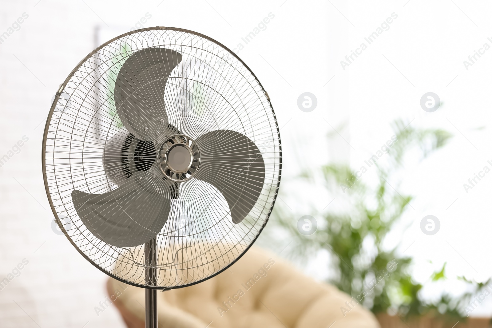 Photo of Modern electric fan in room. Space for text