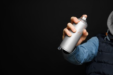 Photo of Man holding used can of spray paint on black background, closeup. Space for text
