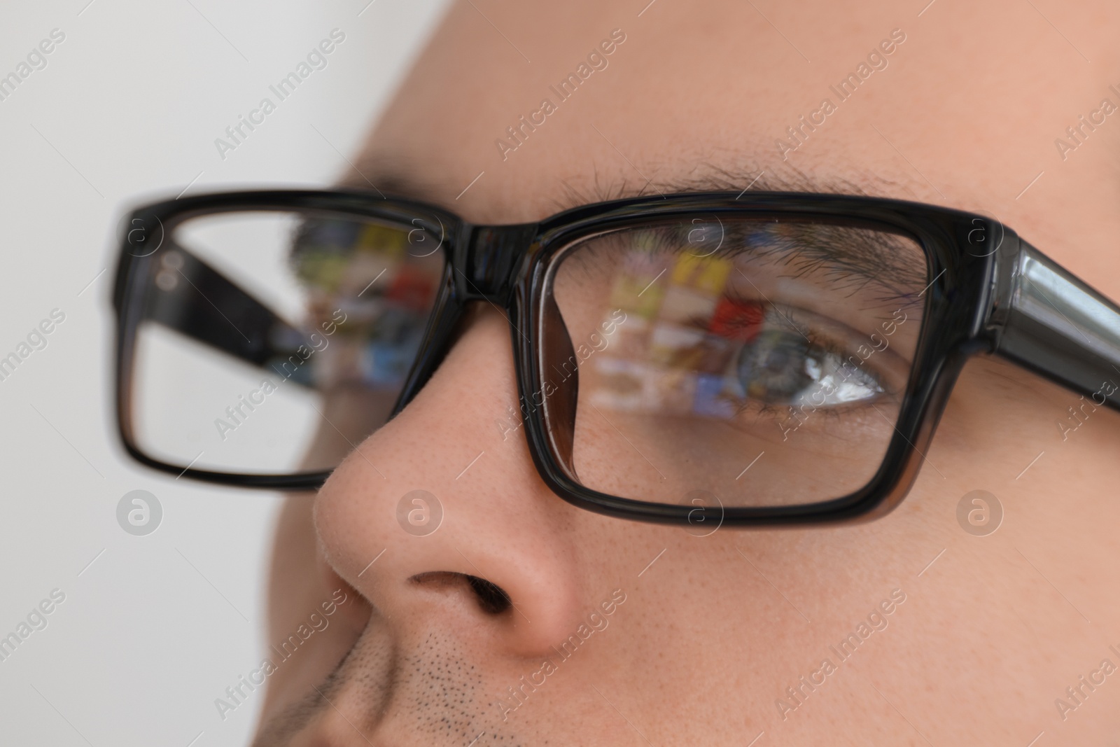 Photo of Man wearing glasses on light background, closeup