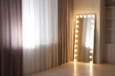 Modern mirror with light bulbs in makeup room, blurred view