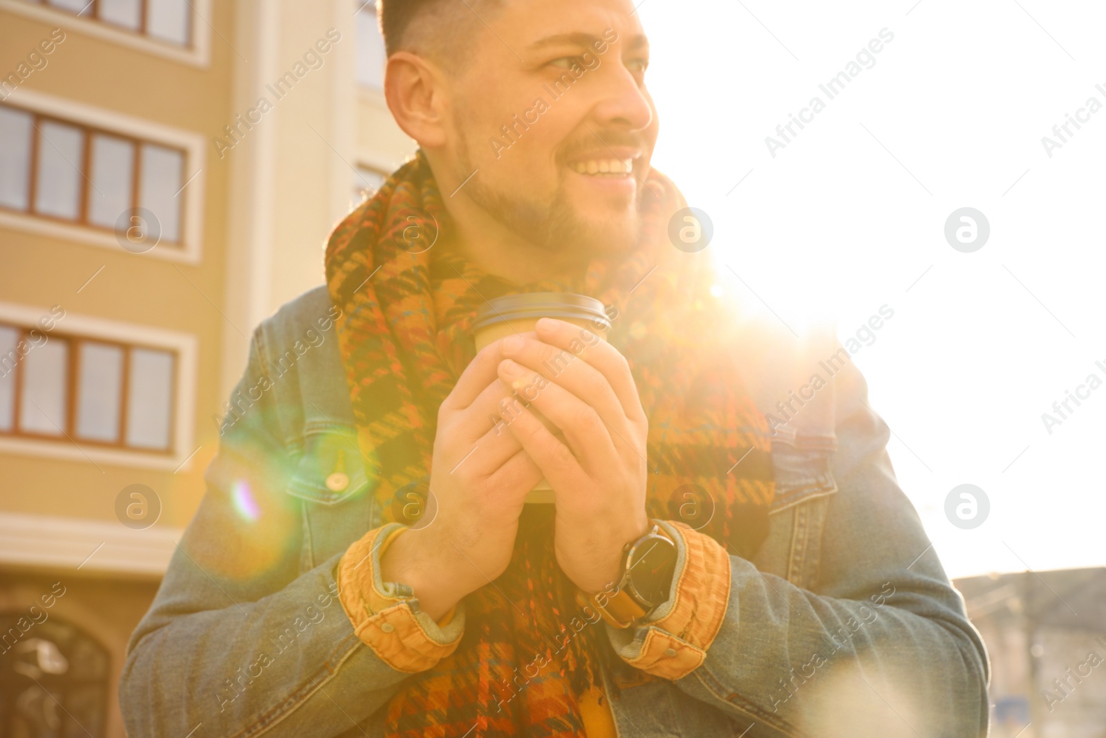 Photo of Man with cup of coffee on city street in morning