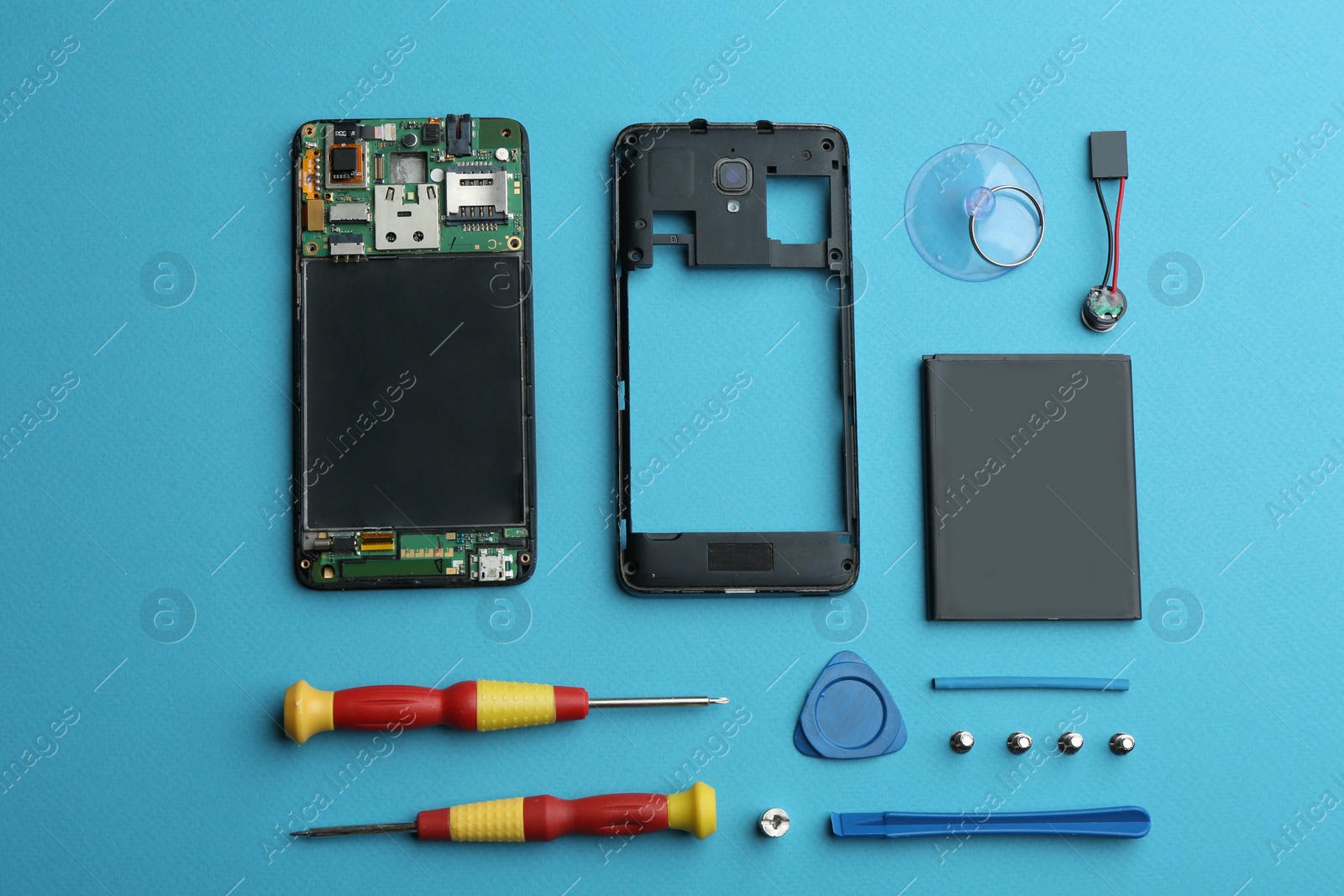 Photo of Disassembled mobile phone and repair tools on blue background, flat lay