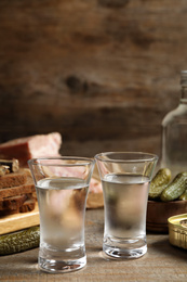 Photo of Cold Russian vodka with snacks on wooden table