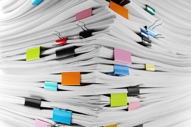 Photo of Stack of documents with colorful binder clips, closeup