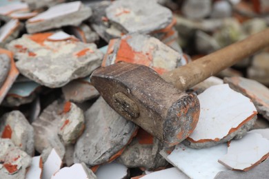 Sledgehammer on pile of broken bricks, closeup