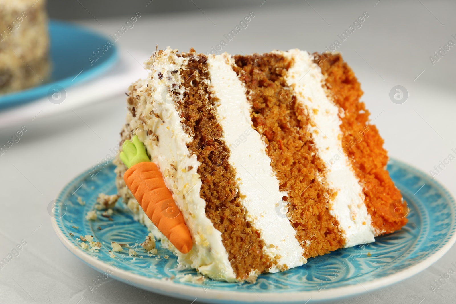 Photo of Plate with piece of tasty carrot cake on light table, closeup