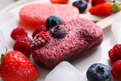 Tasty berry ice pops on plate, closeup. Fruit popsicle