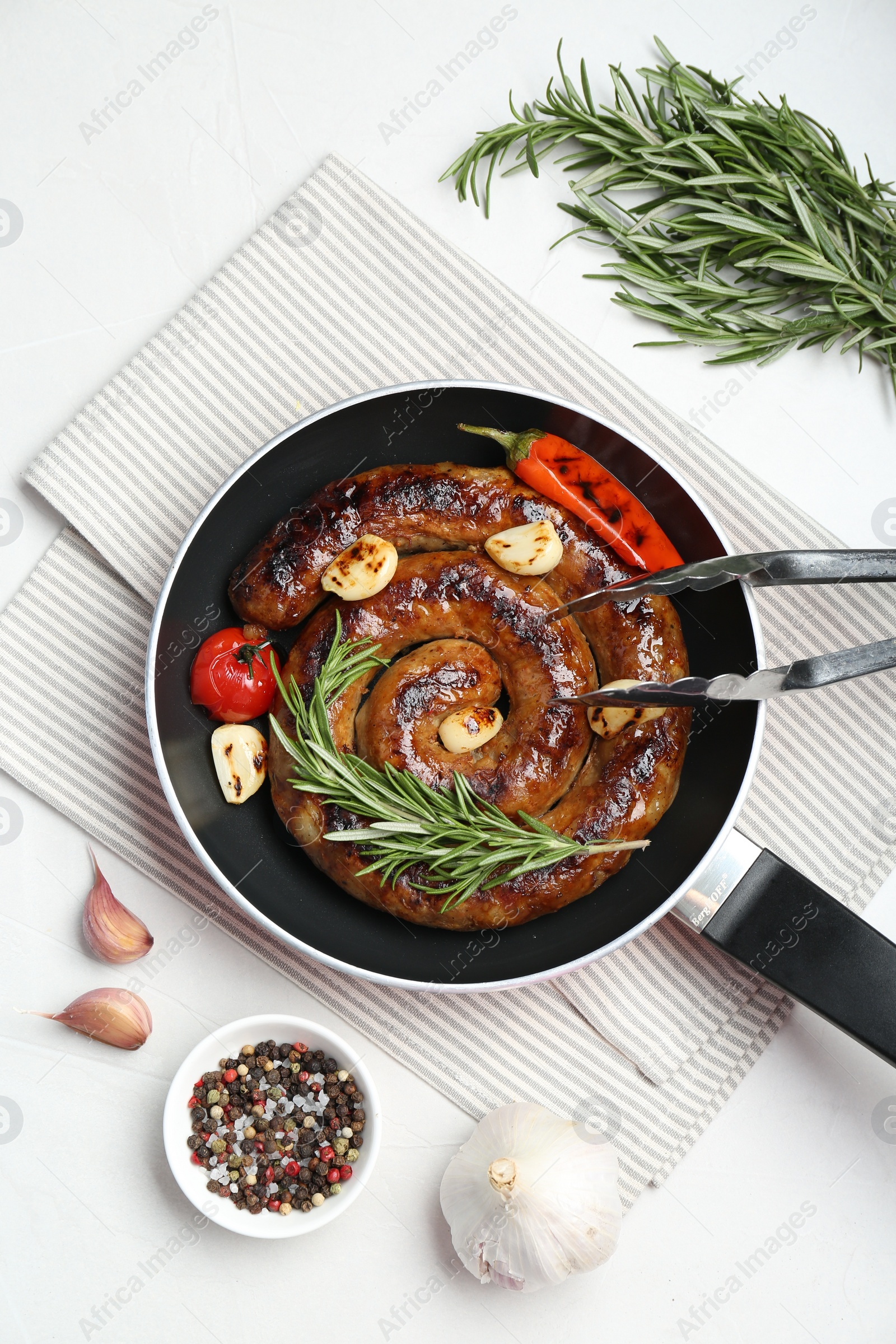 Photo of Delicious homemade sausage with garlic, tomato, rosemary and chili served on white table, flat lay