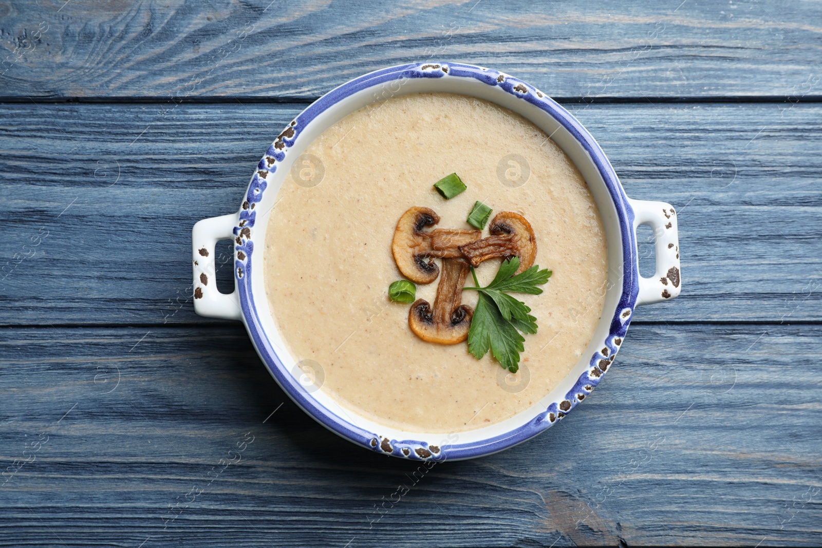 Photo of Bowl of fresh homemade mushroom soup on wooden background, top view