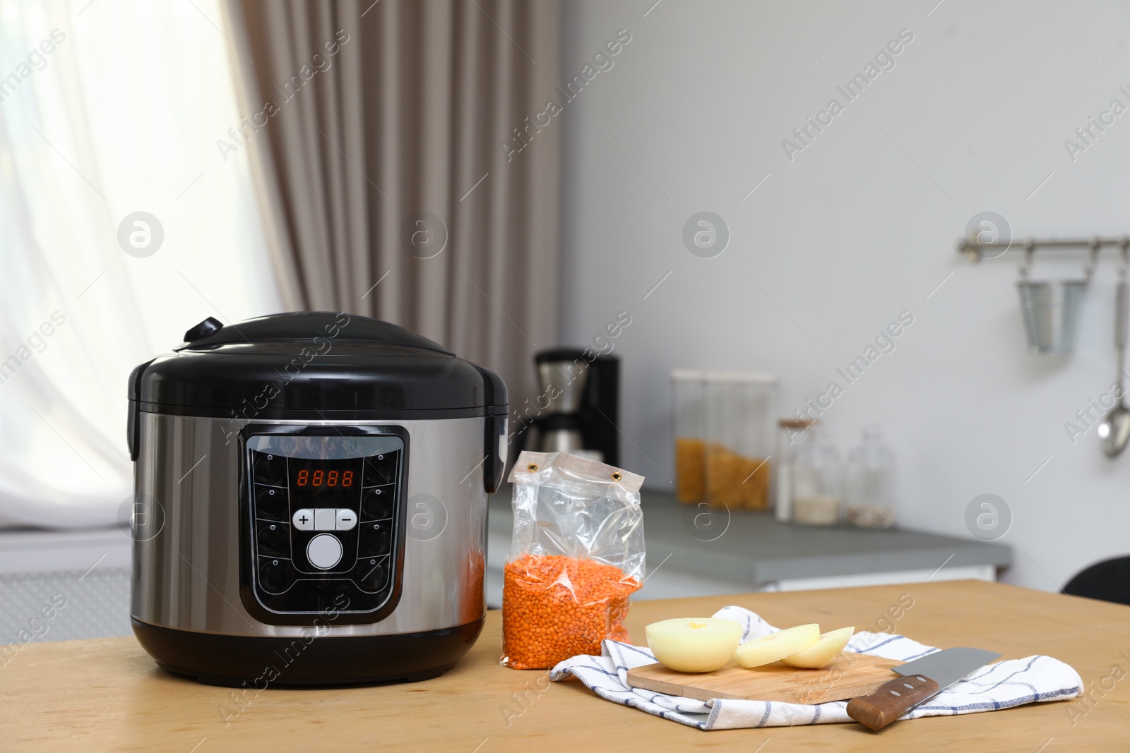 Photo of New modern multi cooker and products on table in kitchen. Space for text