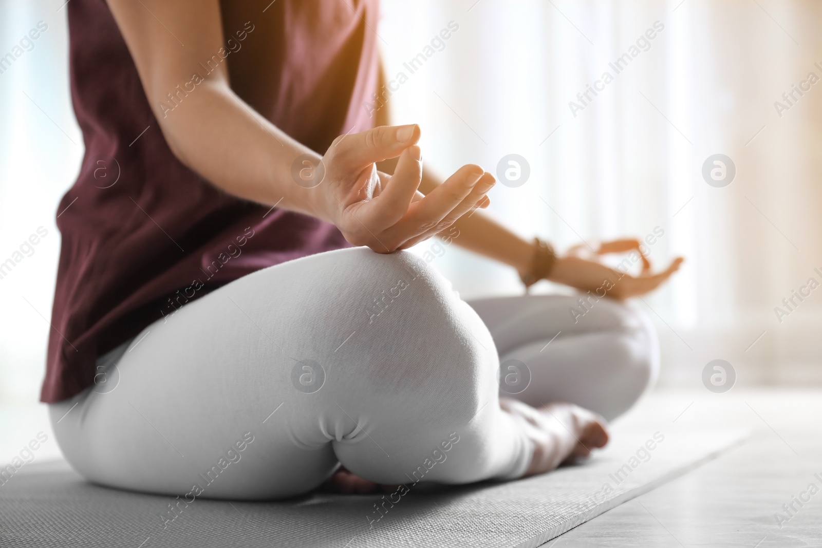 Photo of Woman practicing yoga on floor indoors, closeup. Space for text