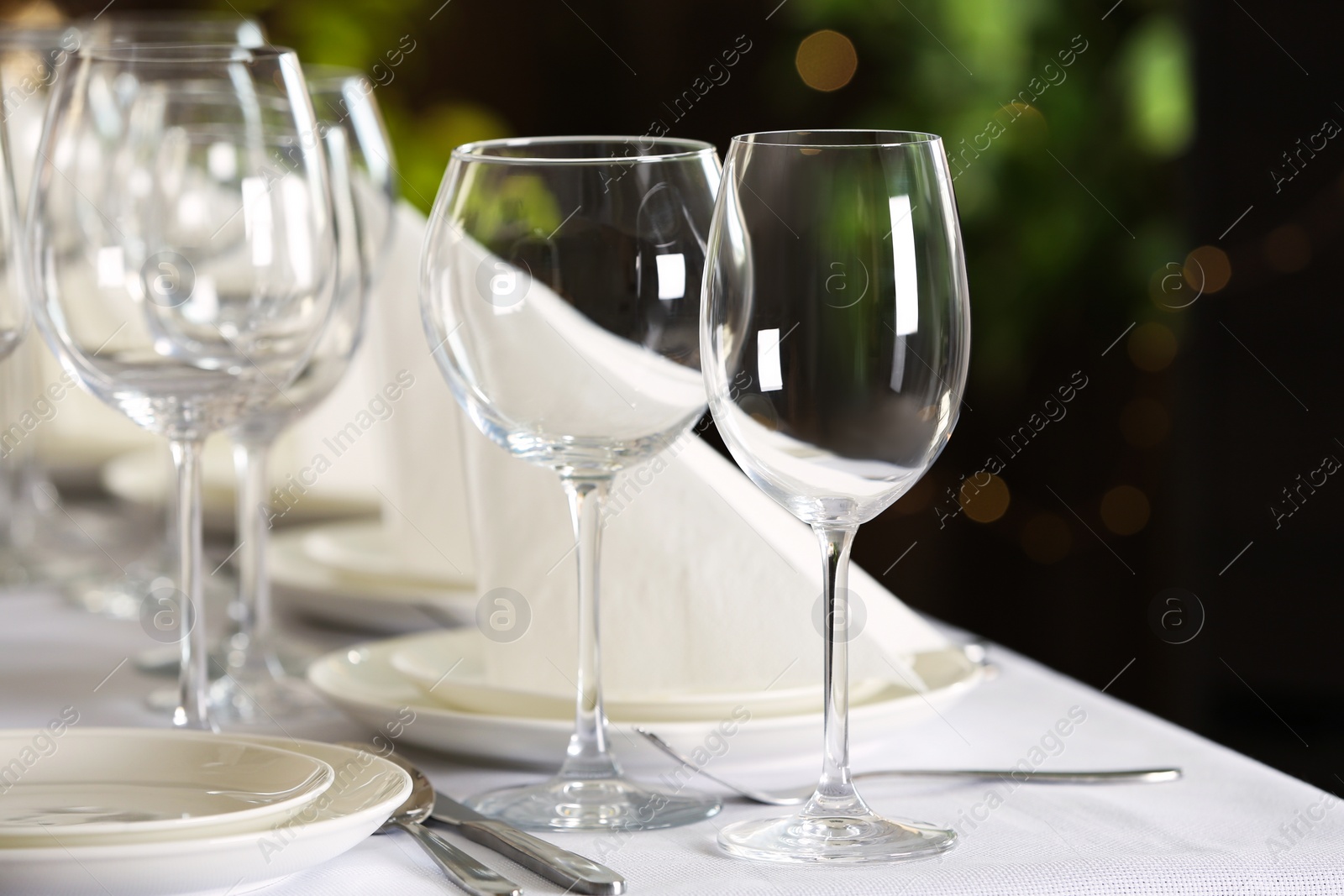 Photo of Table setting with empty glasses, plates and cutlery indoors