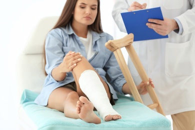 Woman with broken leg in cast on couch