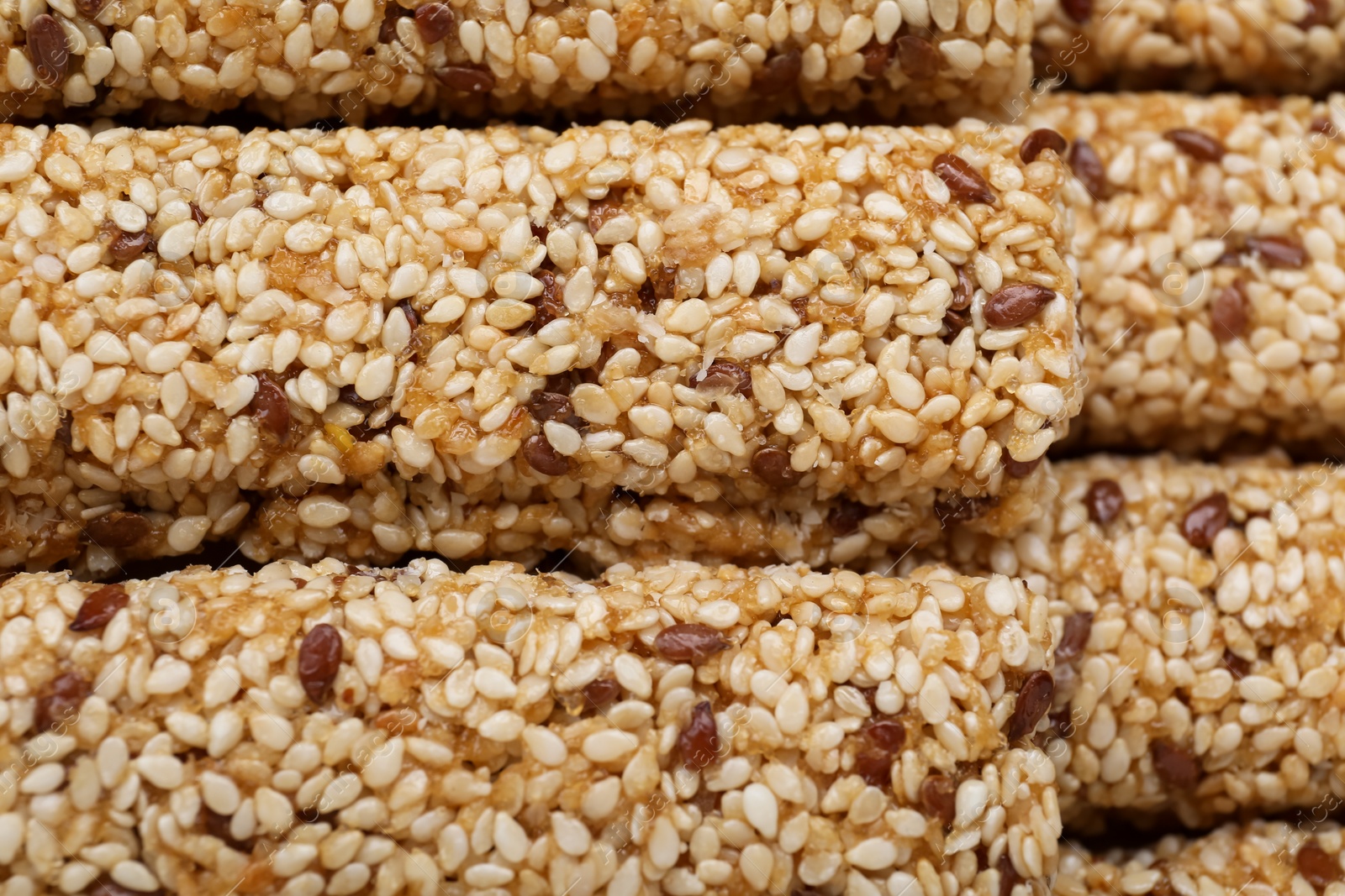 Photo of Tasty sesame seed bars as background, top view