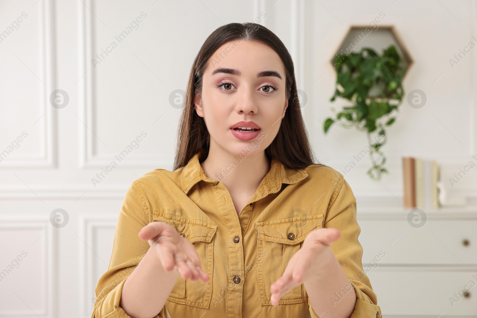 Photo of Beautiful young woman having online video call at home, view from camera