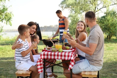Photo of Happy families with little children having picnic in park