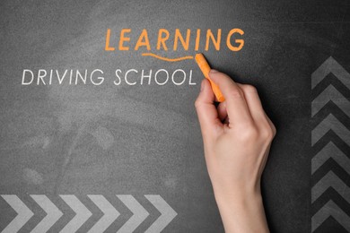 Image of  Driving school concept. Woman with orange chalk near blackboard, closeup