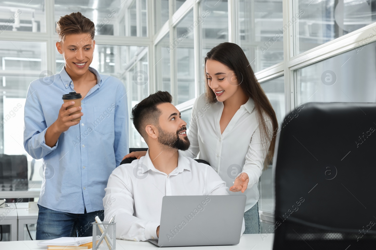 Photo of Colleagues working together in open plan office