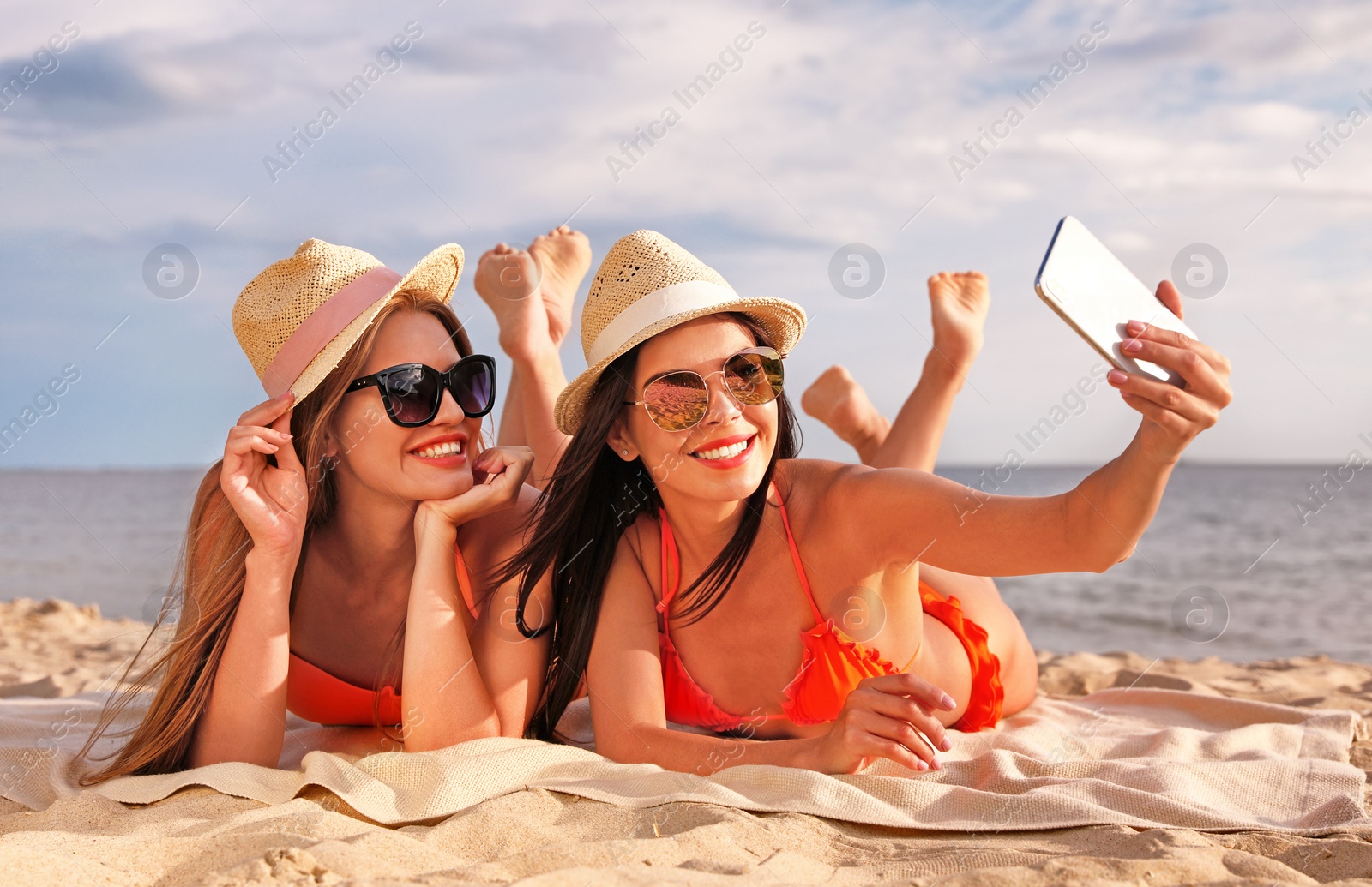 Photo of Young couple in bikini taking selfie on beach