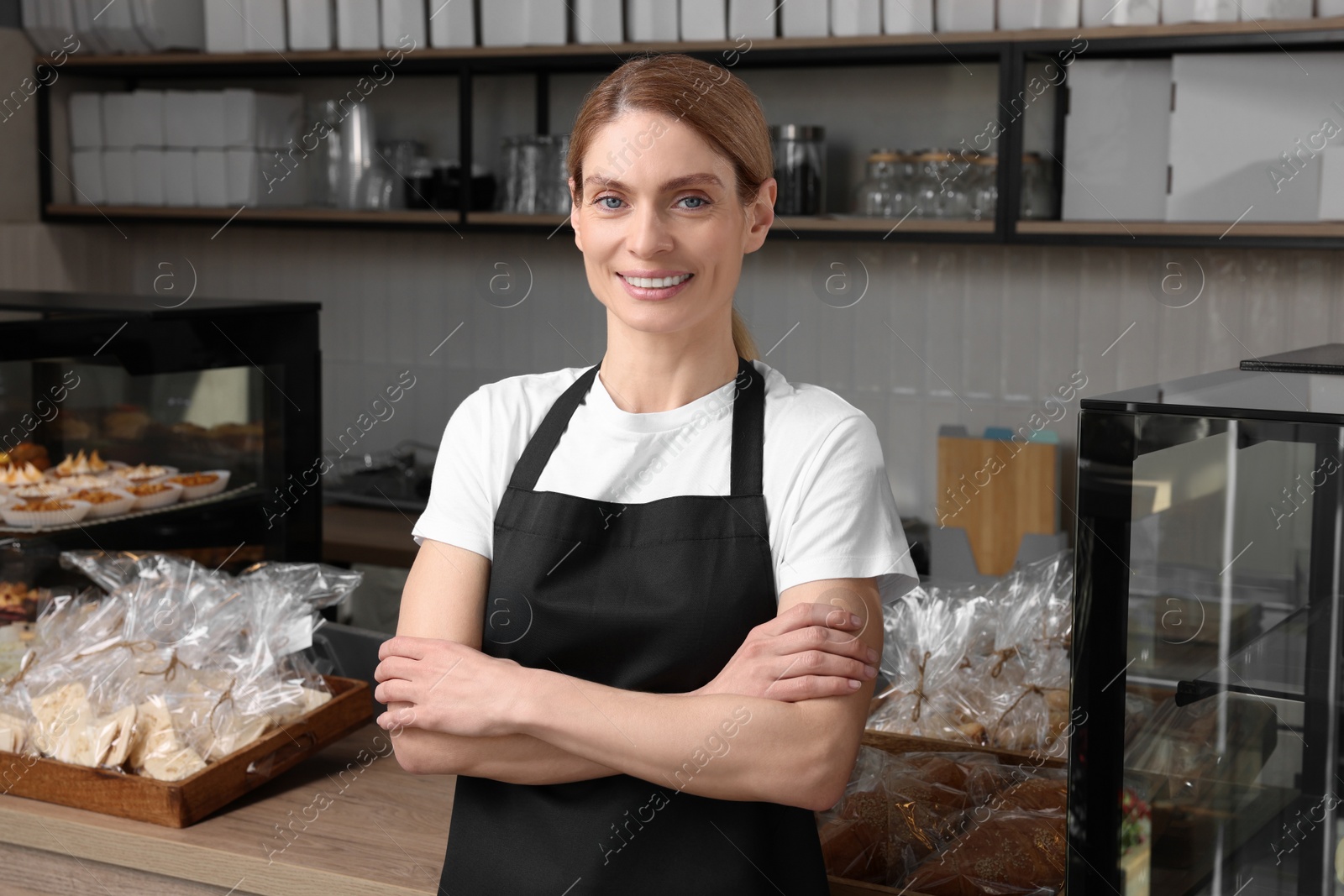 Photo of Portrait of happy seller in bakery shop