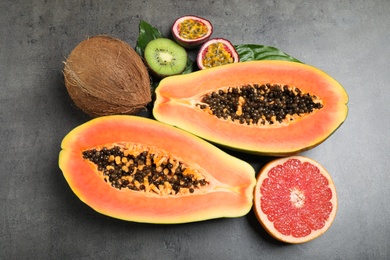 Fresh ripe papaya and other fruits on grey table, flat lay