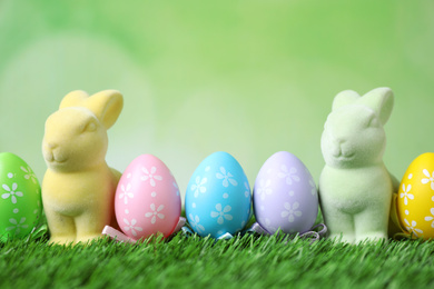 Easter bunnies and painted eggs on green grass