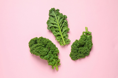 Photo of Fresh kale leaves on pink background, flat lay