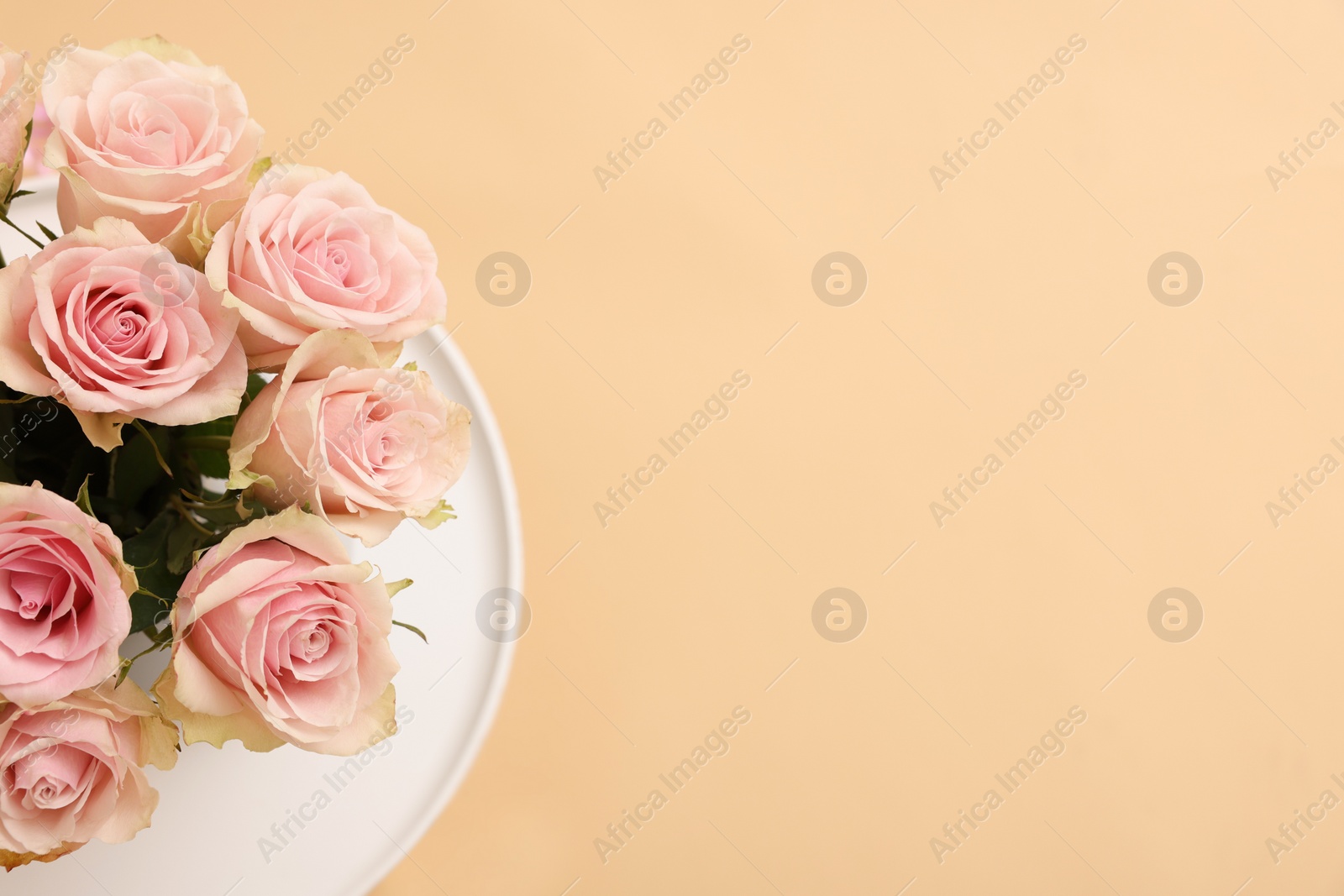 Photo of Beautiful bouquet of rose flowers on coffee table, above view and space for text