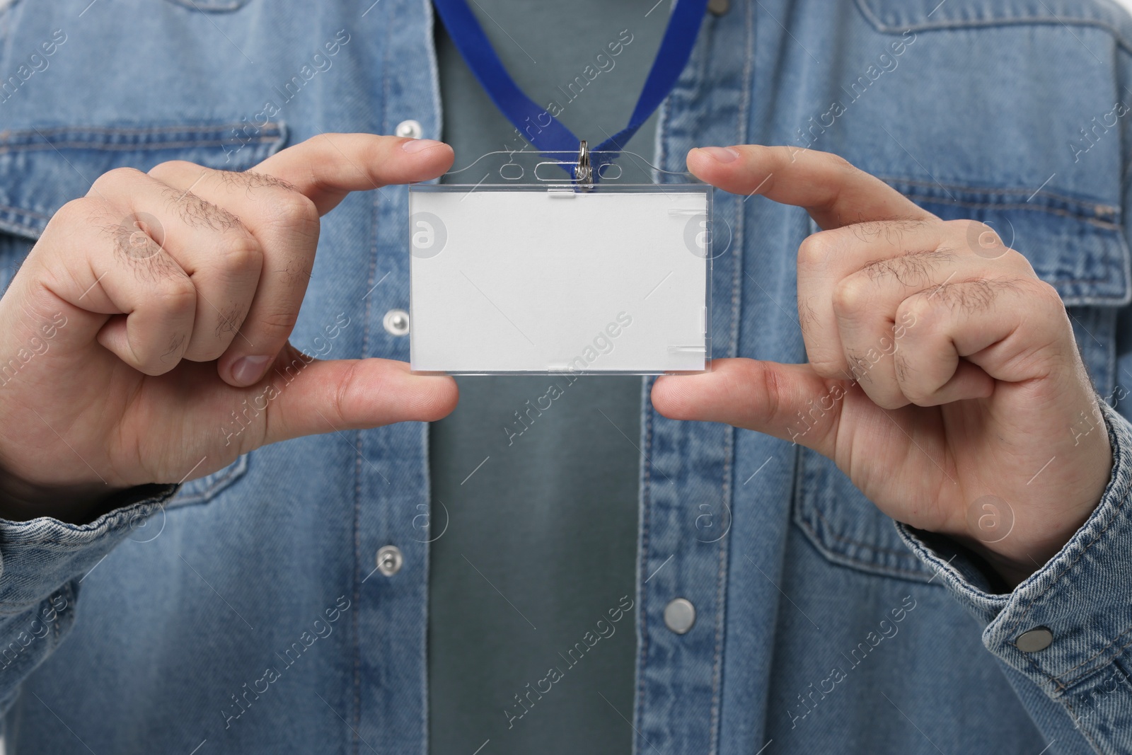 Photo of Man holding blank badge with string, closeup