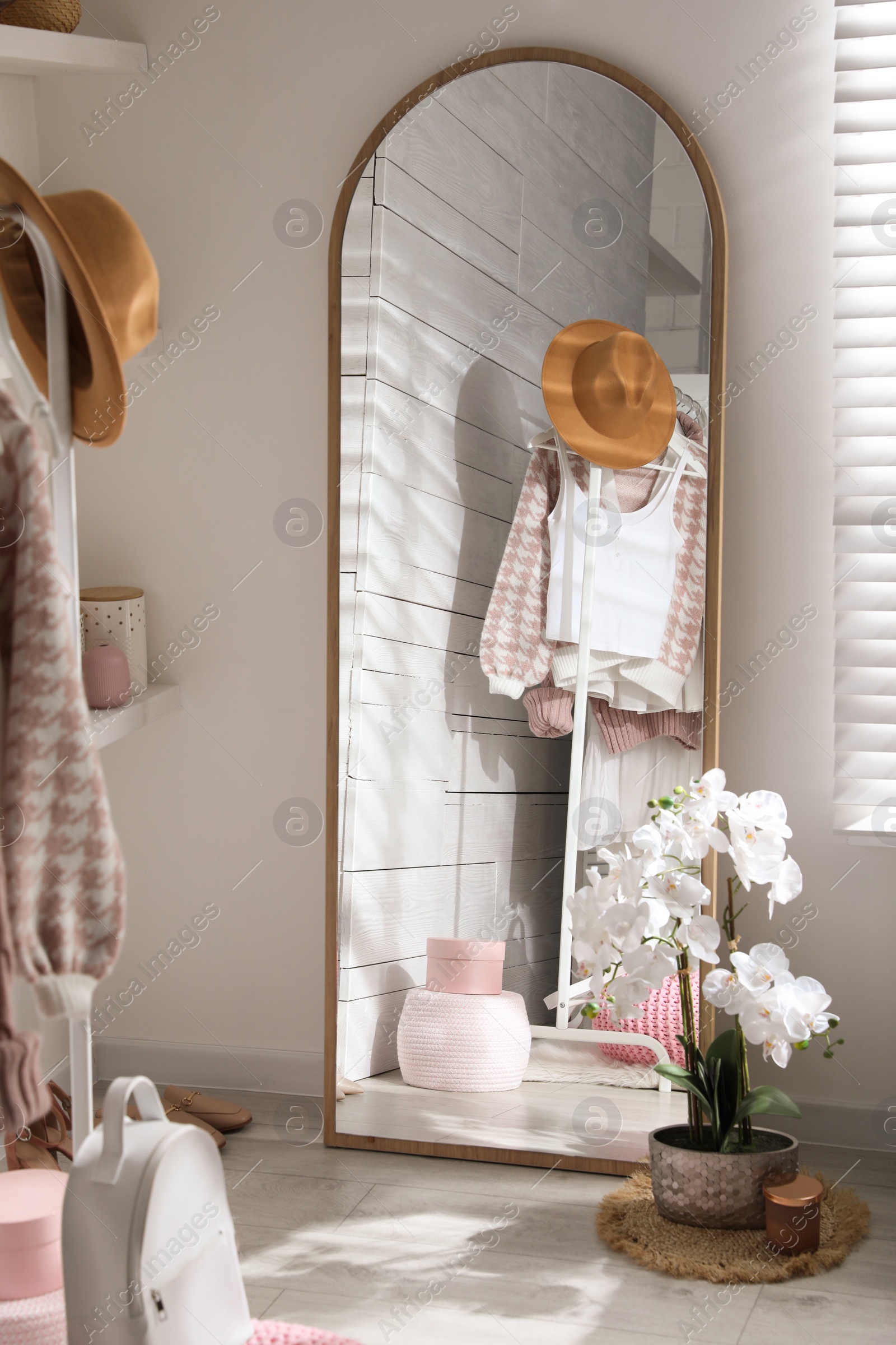 Photo of Big mirror, shoes and decorative elements in dressing room. Interior design