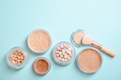 Flat lay composition with various makeup face powders on color background. Space for text