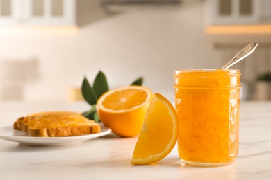 Photo of Delicious orange marmalade and citrus fruit slice on white table. Space for text