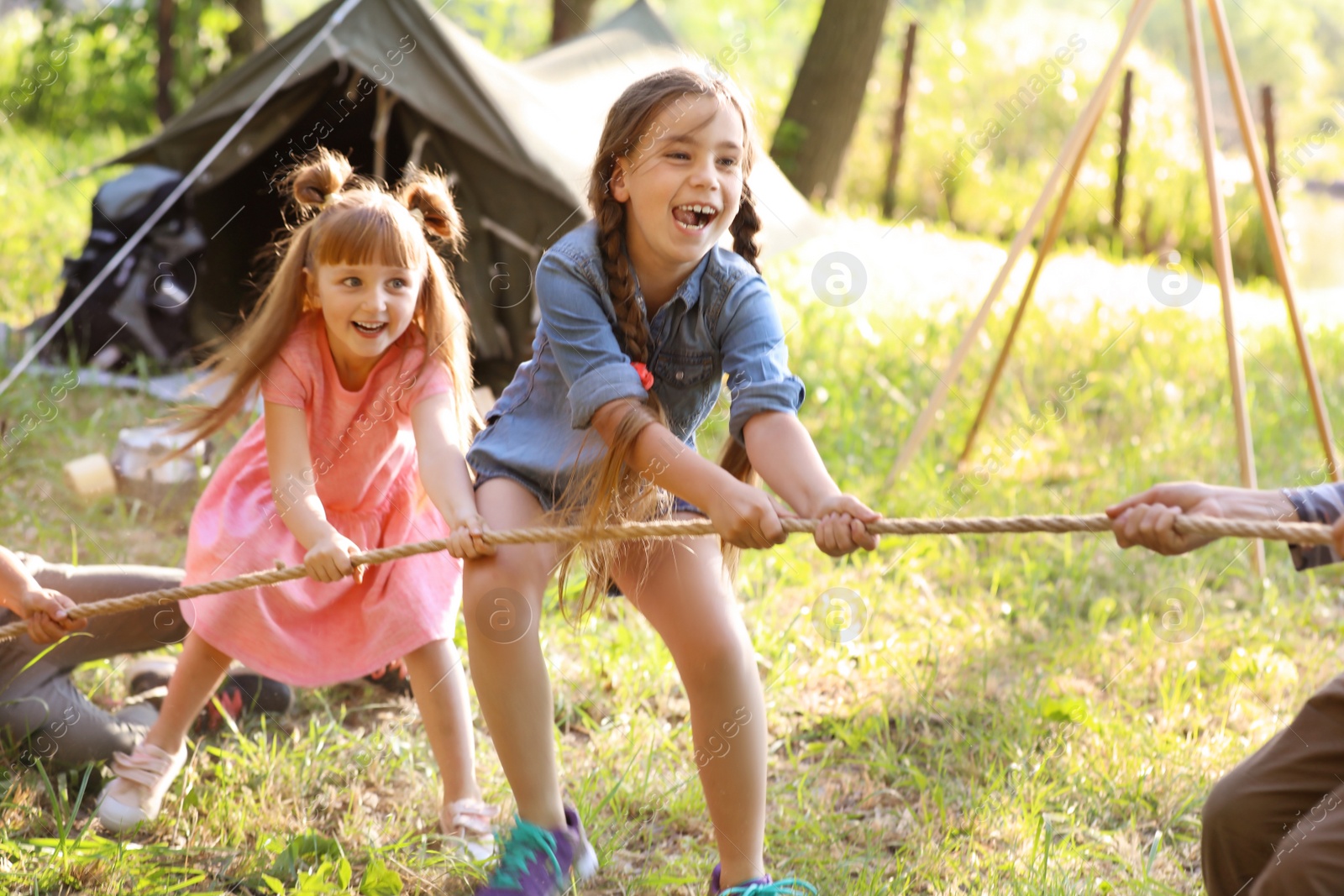 Photo of Little children pulling rope outdoors. Summer camp