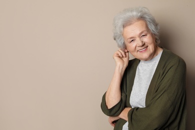 Portrait of mature woman on color background. Space for text